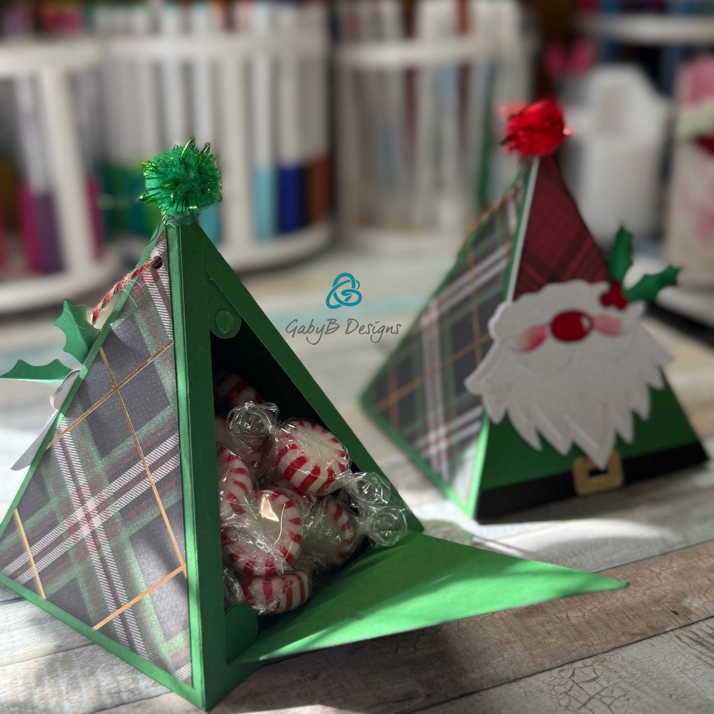 Open triangular holiday gift box with peppermint candies and gift card