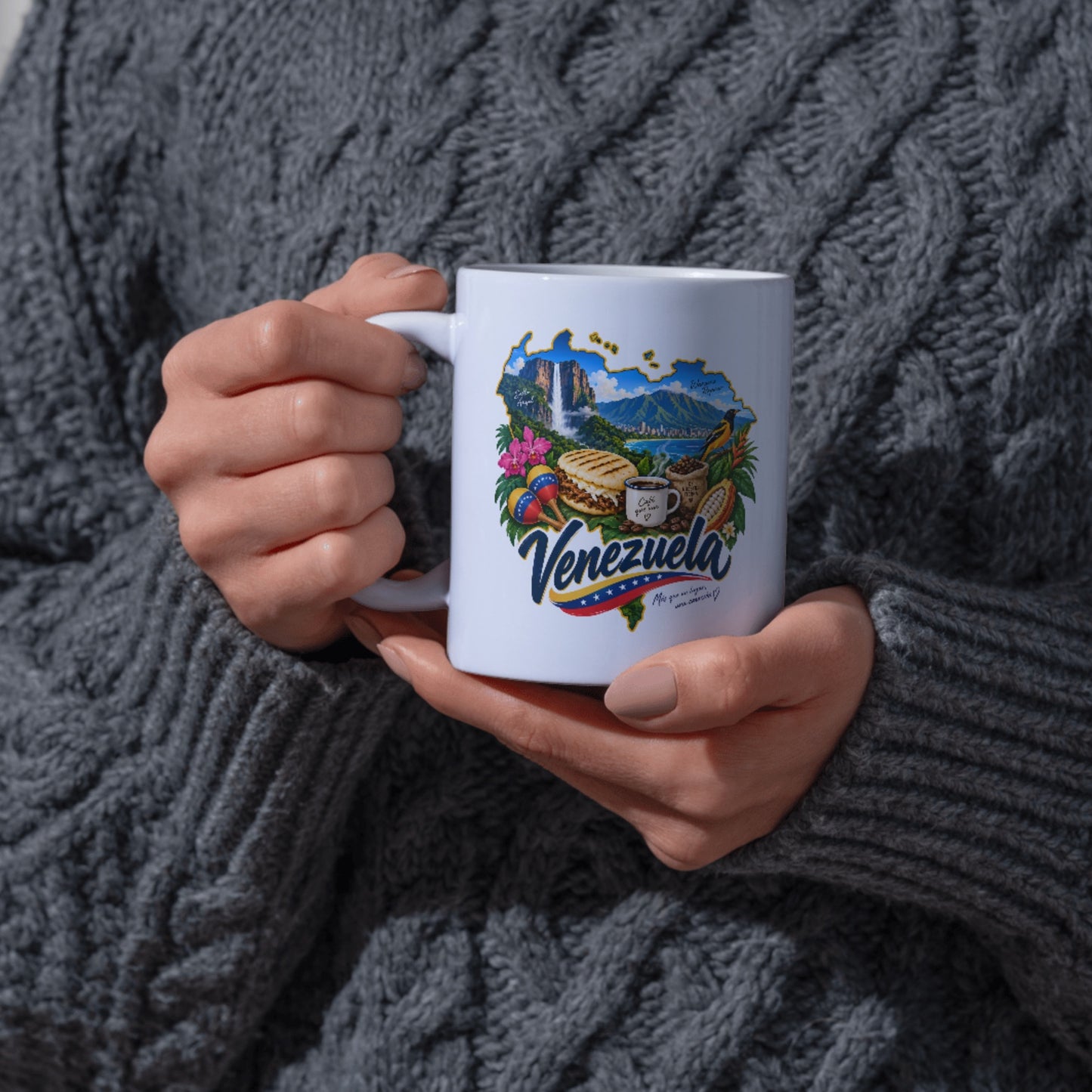 White Venezuela ceramic mug held in hands, featuring colorful Venezuelan cultural artwork.