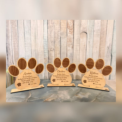 Three personalized engraved dog paw keepsakes with names and messages
