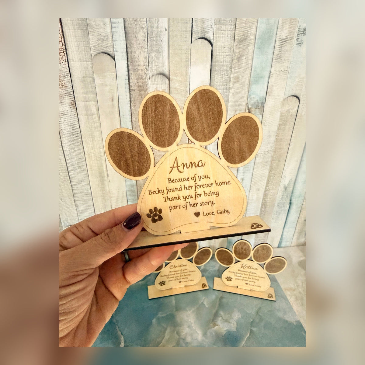 Personalized engraved wooden dog paw keepsake displayed on its stand