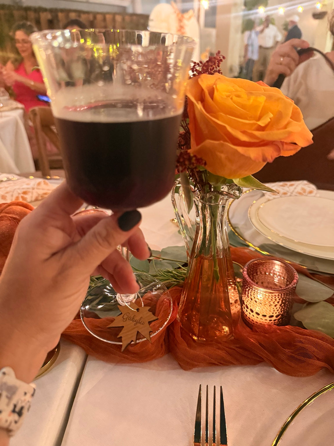 Personalized maple leaf charm on a wine glass at a celebration