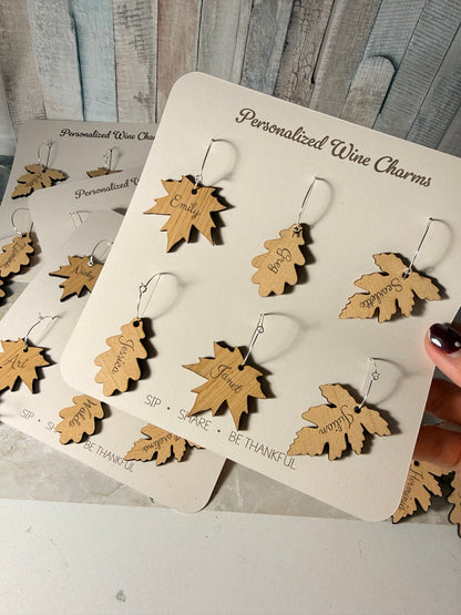 Mixed personalized wooden leaf wine charms on presentation cards