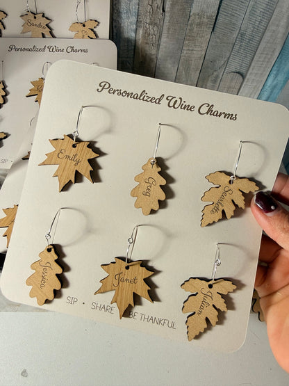 Six personalized wooden wine charms in three leaf shapes